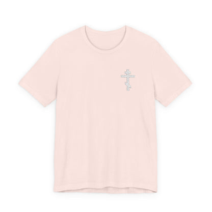 Soft pink unisex t-shirt featuring a small white embroidered Orthodox cross on the left chest and “May I Never Boast Except in the Cross (Gal 6:14),” made from premium cotton for a comfortable fit.