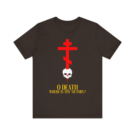 Brown T-shirt with a red Orthodox cross above a white skull and yellow text: O Death Where Is Thy Victory? (1 Corinthians 15:55), symbolizing Christ’s Resurrection and victory over death. Lightweight cotton, unisex fit.