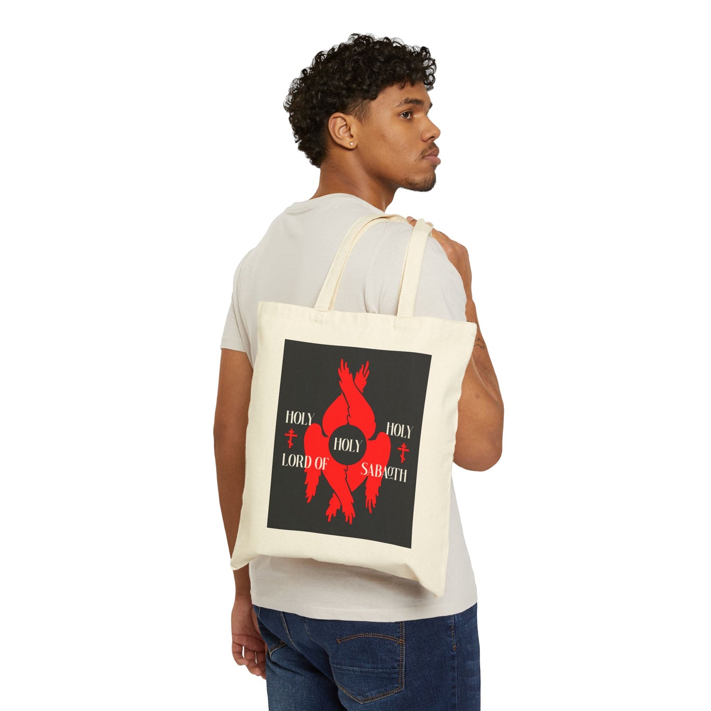 Man with short curly hair carries a black cotton tote bag featuring red seraphim wings, Orthodox crosses, and "Holy Holy Holy Lord of Sabaoth" from Isaiah 6:3.
