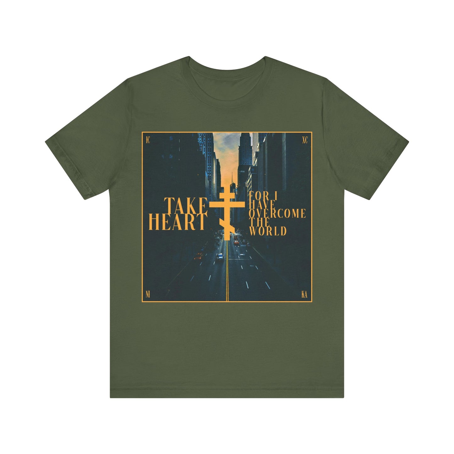 Military green cotton T-shirt featuring a modern city street scene and gold cross, with “Take Heart, For I Have Overcome the World” (John 16:33). A redemptive Orthodox Christian design inspiring joy over sorrow.