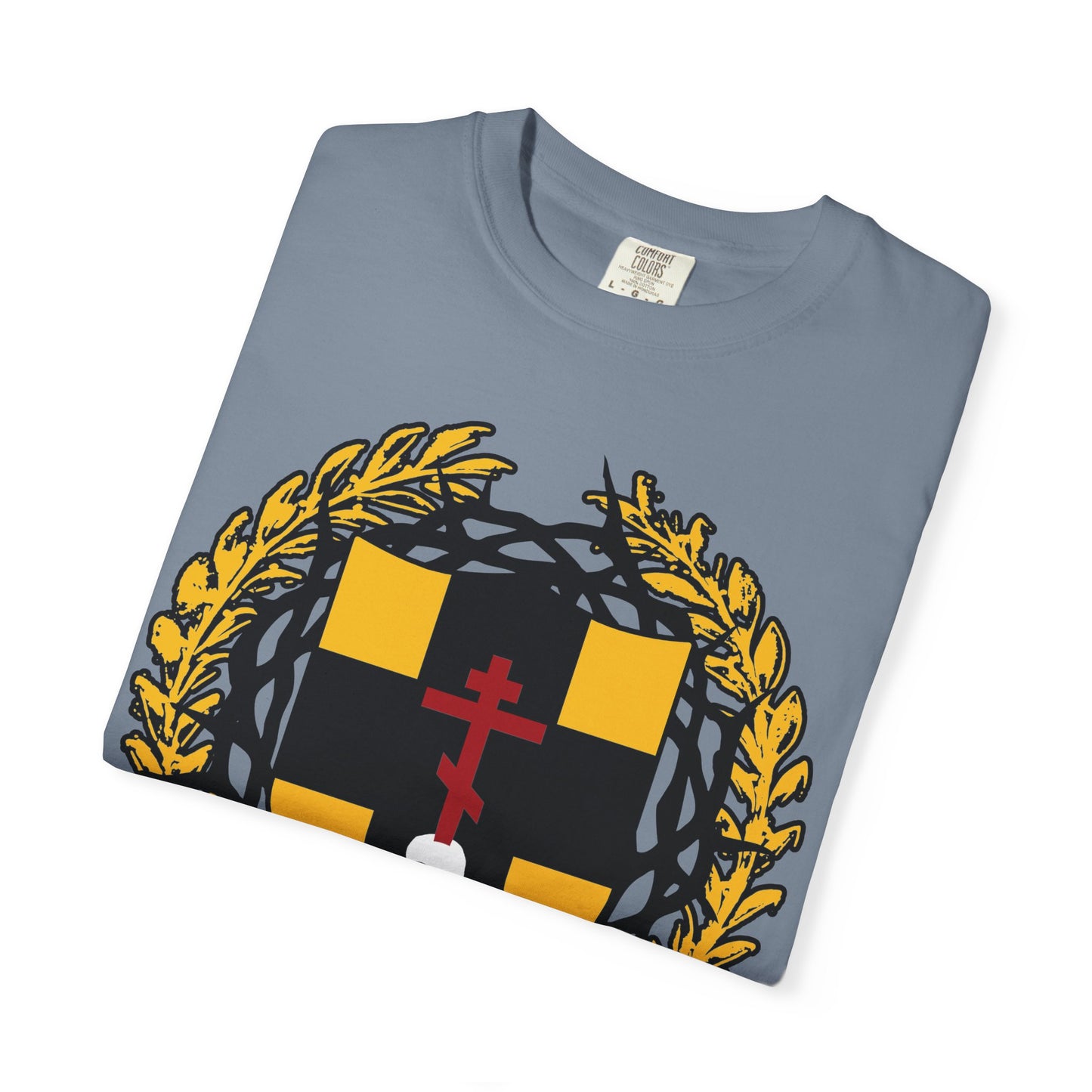 Folded gray heavyweight cotton unisex t-shirt featuring a heraldic black and yellow shield with an Orthodox cross stabbing a skull, adorned with a gold laurel wreath and crown of thorns, inspired by Colossians 1:18—“First-Born from the Dead.”.