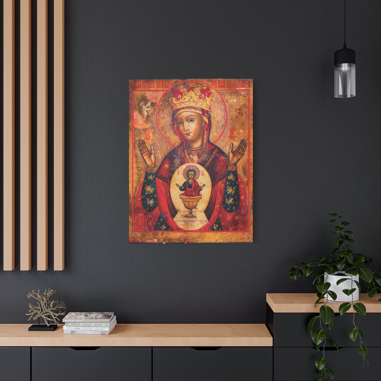 The “Mother of God of Nicaea Russian Orthodox Christian Icon | Panagia | Theotokos Mary | Religious Canvas Sacred Wall Art” is displayed on a dark wall above a modern desk adorned with plants and books.