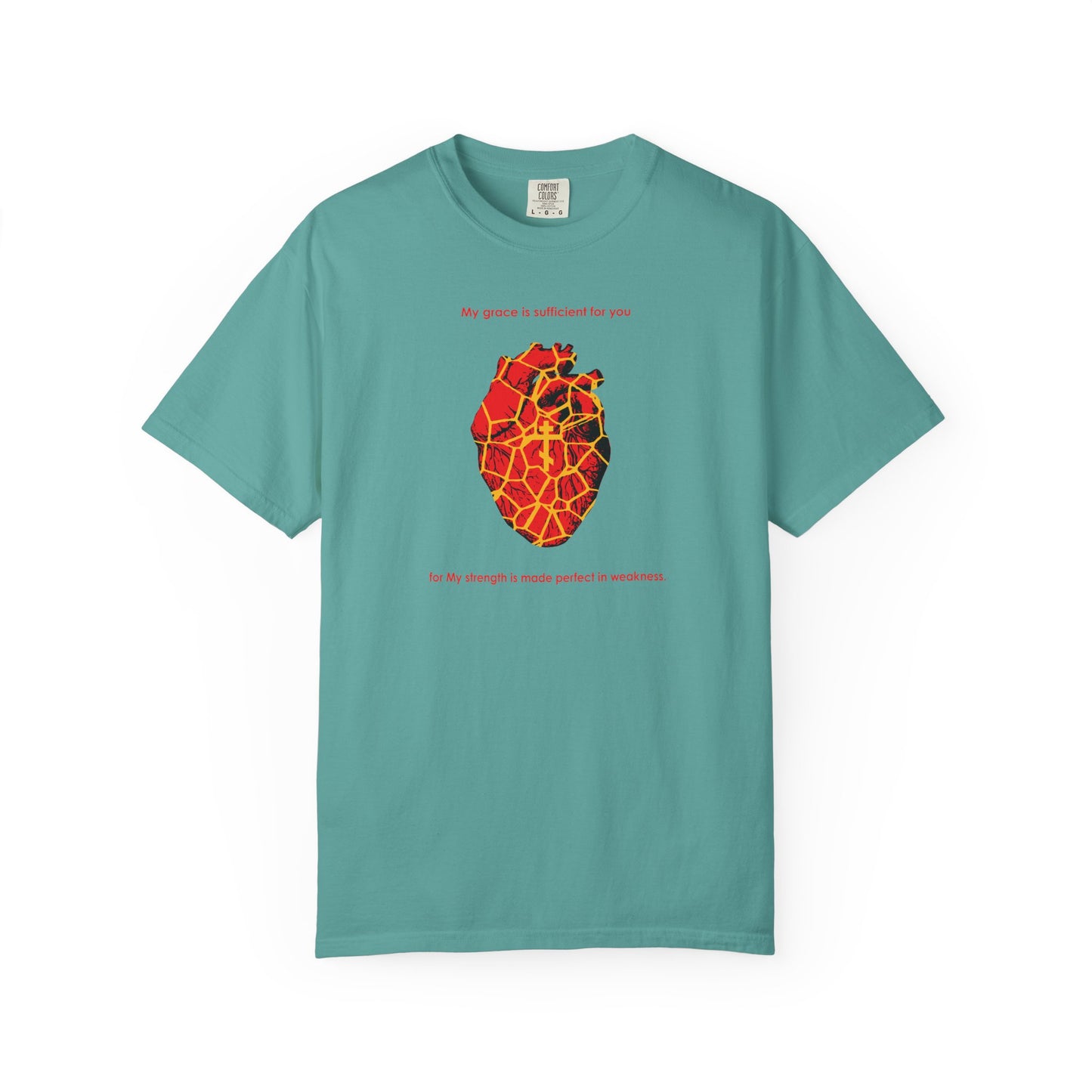 Seafoam heavyweight cotton unisex tee featuring a kintsugi-style golden broken heart, an Orthodox cross, and the text “My strength is made perfect in weakness” (2 Cor 12:9)—a beautiful symbol of grace mending every broken spirit.