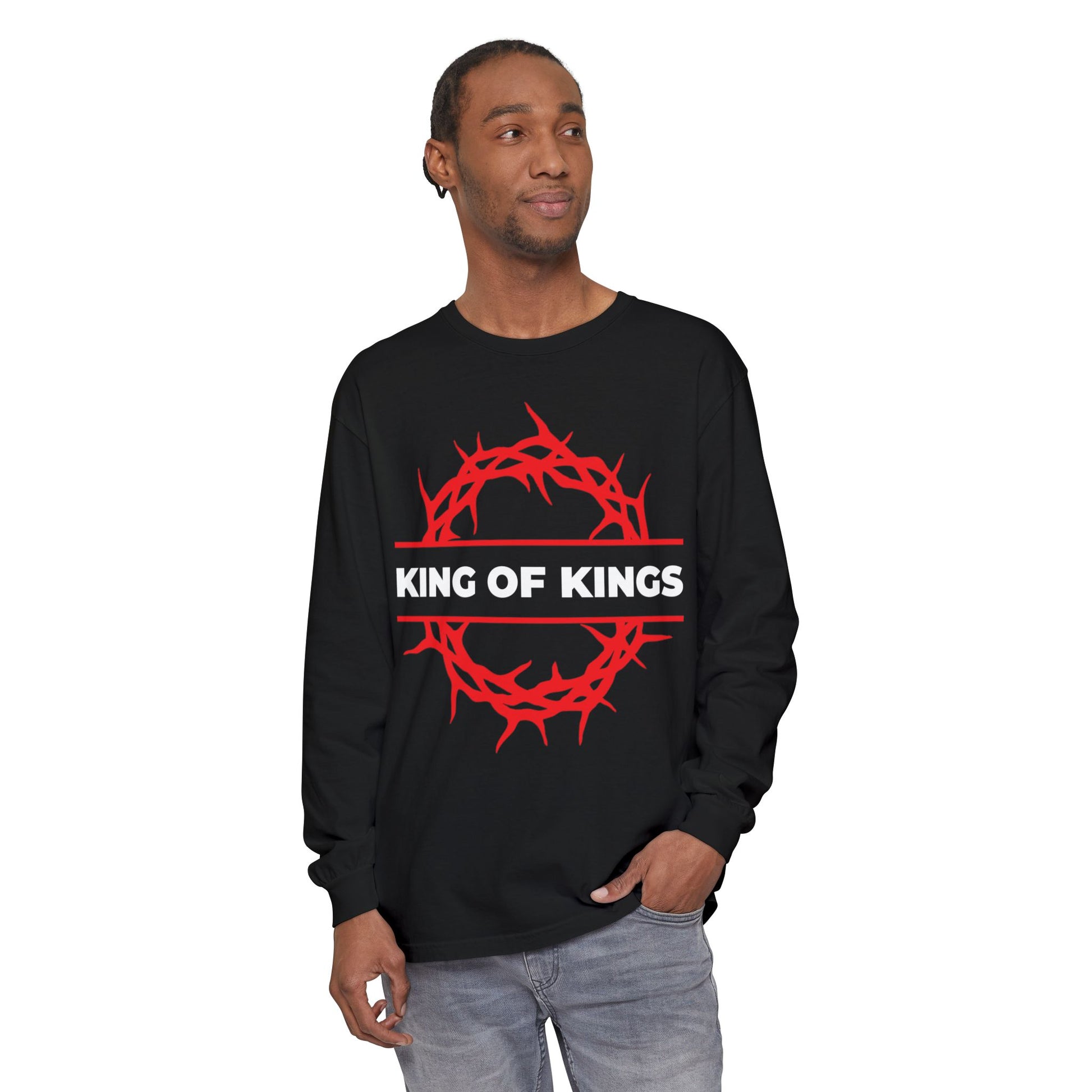 A man wears the "King of Kings Crown of Thorns | The King of Glory | Christ is King | Revelation 19:16" Christian cotton long sleeve shirt, featuring a black design with a red crown of thorns, inspired by Revelation 19:16.