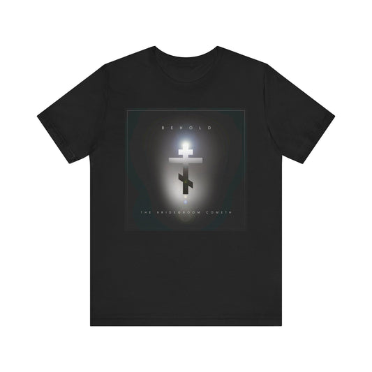 The black "Behold the Bridegroom Minimalist Cinematic Lens Flare" Orthodox Christian t-shirt features BEHOLD and THE BRIDEGROOM COMETH on the front, serving as a reminder to stay prepared for Christ's return. Made of lightweight cotton, unisex fit.