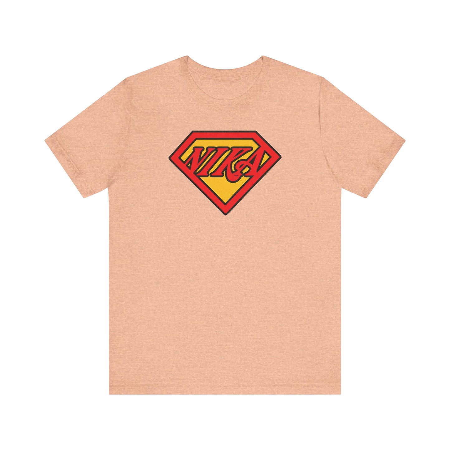 Heather peach unisex tee featuring a bold red and yellow comic book-style "NIKA Superm@n" logo, inspired by the faith and courage of St. John of Kronstadt to conquer passions.