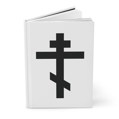 A white hardcover journal featuring a large black Orthodox cross and the quote "May I never boast, except in the cross of our Lord Jesus Christ" (Gal 6:14) on the cover.