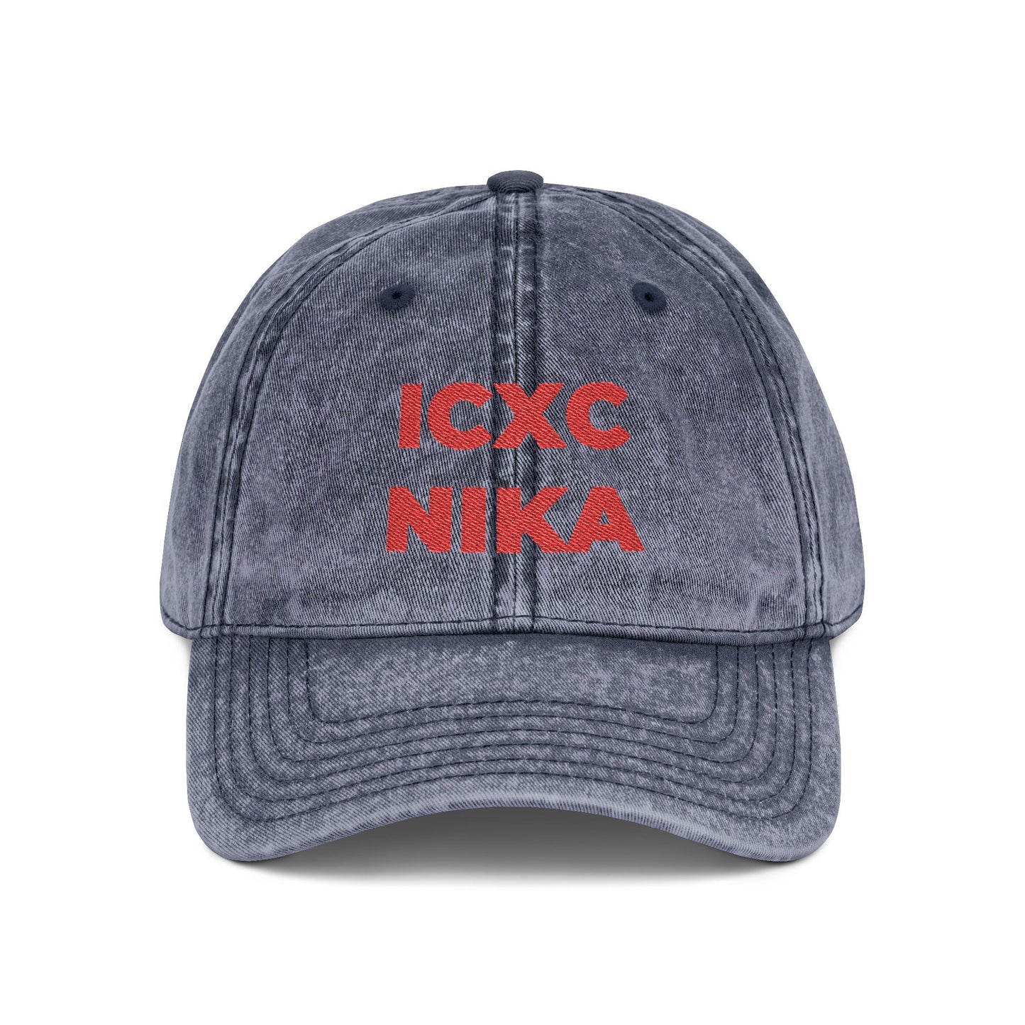 A navy denim cap with red embroidered ICXC NIKA text—a Greek Christogram meaning "Jesus Christ conquers"—on the front.