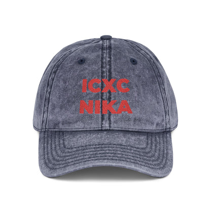 A navy denim cap with red embroidered ICXC NIKA text—a Greek Christogram meaning "Jesus Christ conquers"—on the front.
