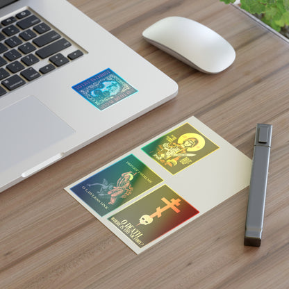 A laptop, mouse, pen, and a card decorated with the Bestseller Mix No. 1 Four Orthodox Stickers—including Theotokos Champion Leader, St Marina, Death Where is Thy Victory, and To Live is Christ—sit on a wooden desk.