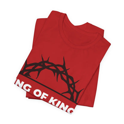 Folded red King of Kings Crown of Thorns tee with partial text "KING OF KIN," inspired by Revelation 19:16—Christ is King, The King of Glory. Orthodox Christian unisex cotton shirt.