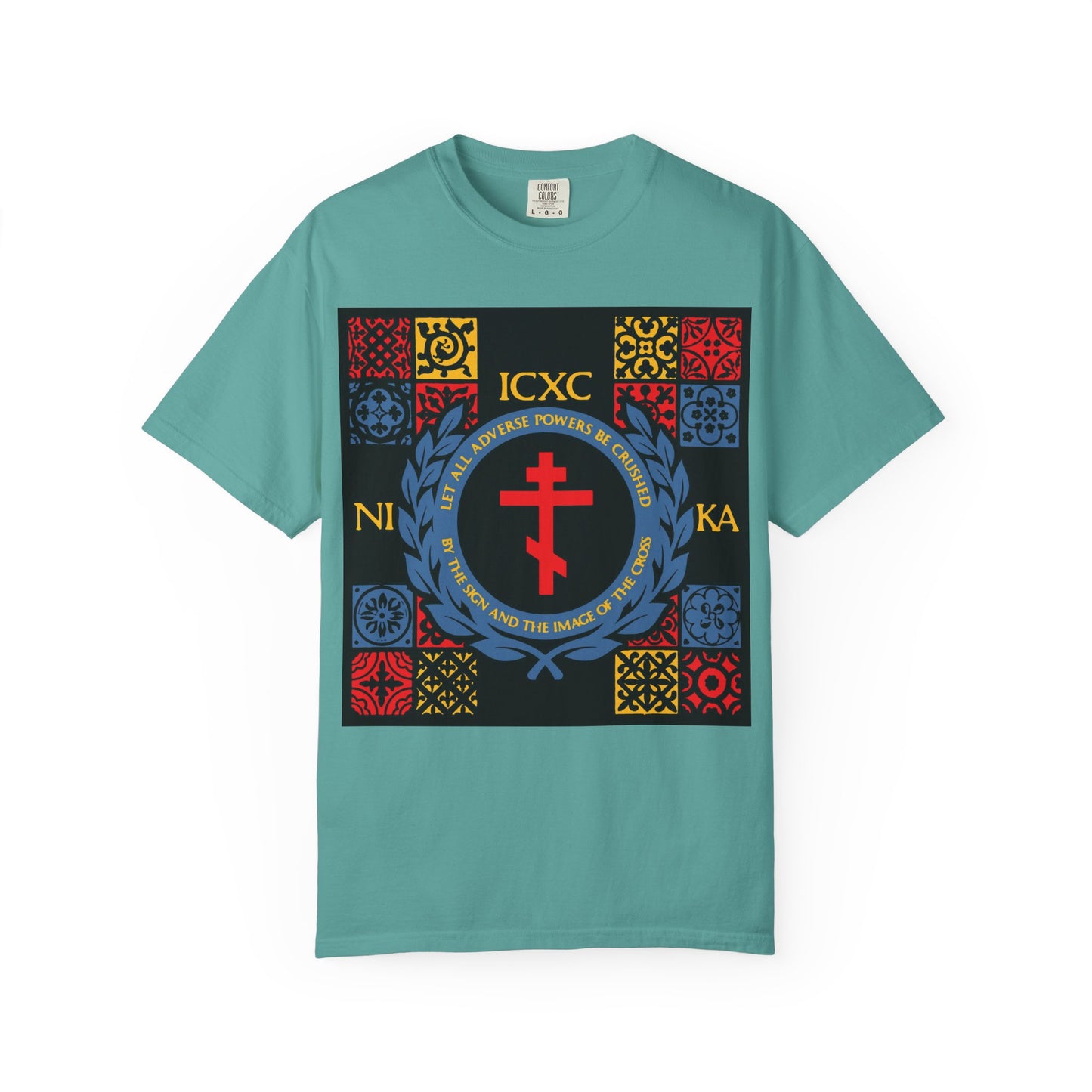 Seafoam heavyweight cotton unisex t-shirt featuring a bold red cross inspired by the Katavasia, Greek letters ICXC NIKA, and a vibrant medieval tile pattern in red, yellow, and blue on the front; product name: "Let All Adverse Powers Be Crushed.
