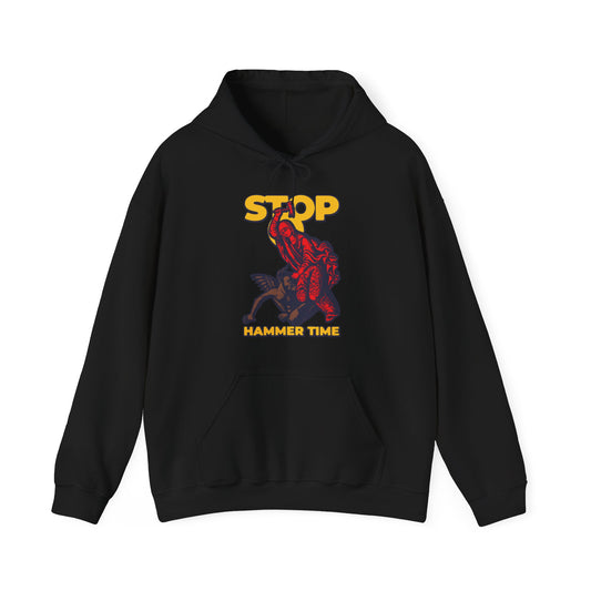 Black hoodie featuring "STOP HAMMER TIME" and artwork of St Marina of Antioch beating the devil with a hammer. Modern Orthodox meme in red, blue, and yellow. Christian-themed design inspired by legendary saints.