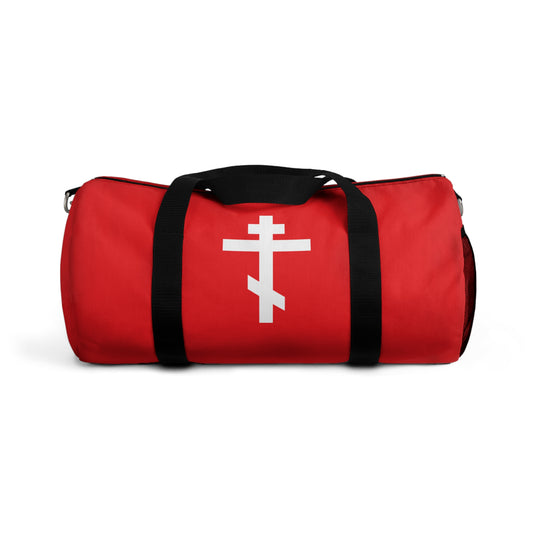 Red gym duffel bag with black handles, adorned with a white Orthodox cross on a red background and the Galatians 6:14 quote: "May I never boast, except in the cross of our Lord Jesus Christ." Orthodox Christian design.