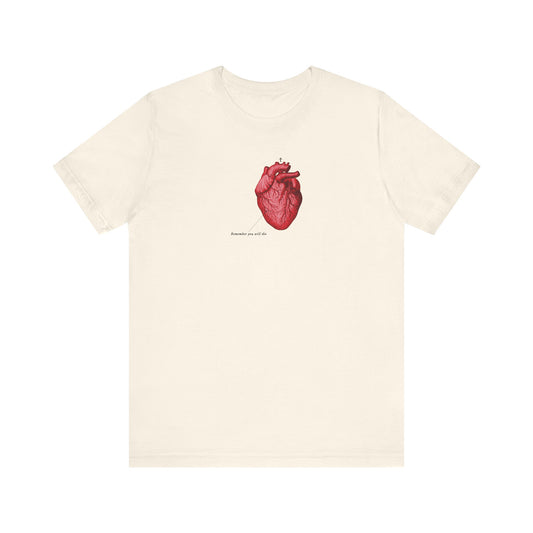 Natural cotton unisex tee featuring a retro medical textbook-style red anatomical heart, Orthodox cross, small text beneath, and “Remember You Will Die” memento mori design—drawing inspiration from St John’s Tone 4 Tuesday Vespers Aposticha.