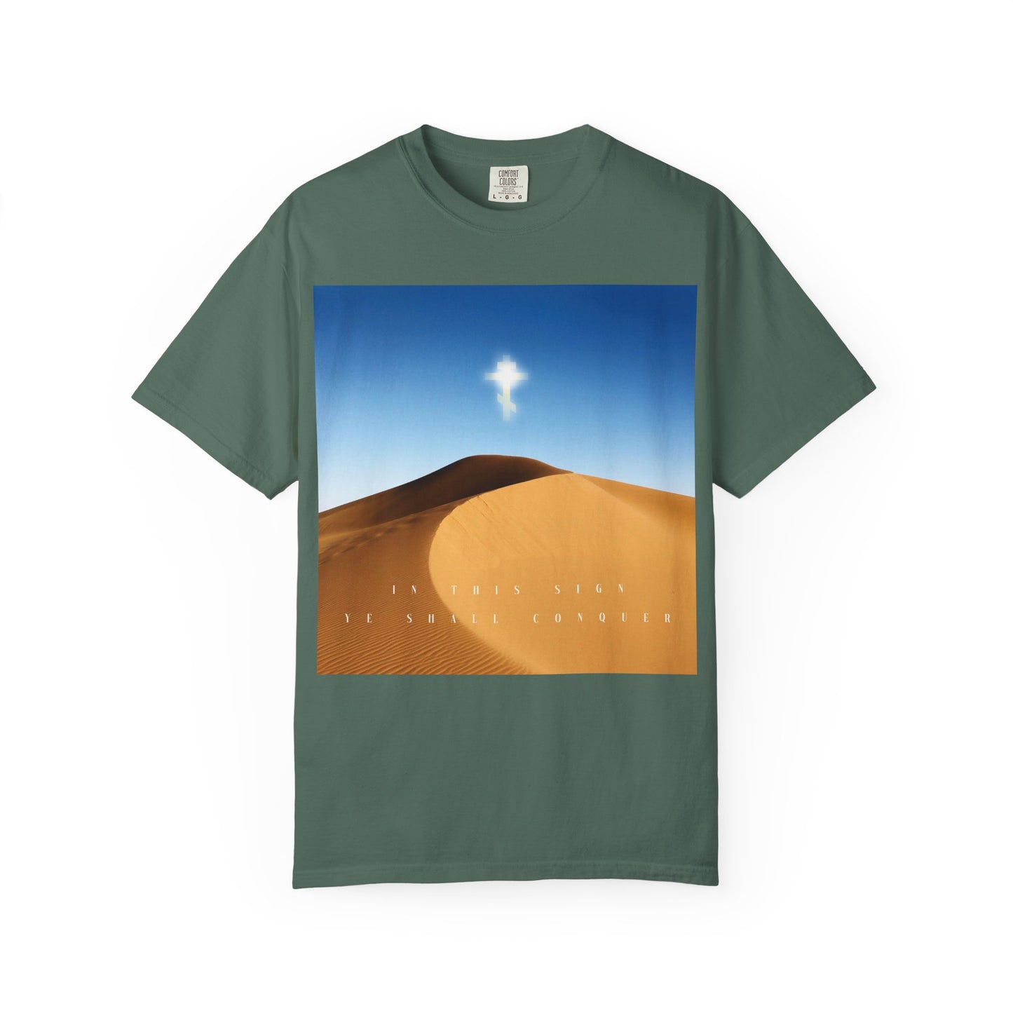 Blue Spruce T-shirt featuring a desert sun scene with a radiant cross in the sky, symbolizing The Cross is the Might of Kings, and text: IN THIS SIGN YE SHALL CONQUER—capturing the enduring strength and beauty of the Orthodox Christian faith.