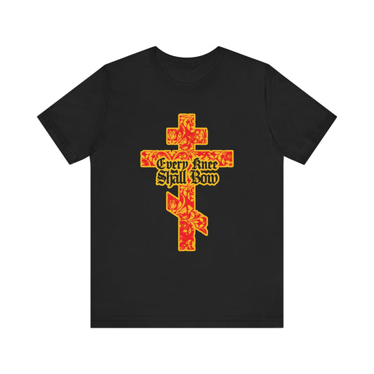 Black "Every Knee Shall Bow" tee features a gold and red floral Orthodox cross with gothic letters, inspired by Isaiah 45:22-24 & Phil 2:7-11. Lightweight cotton unisex design.