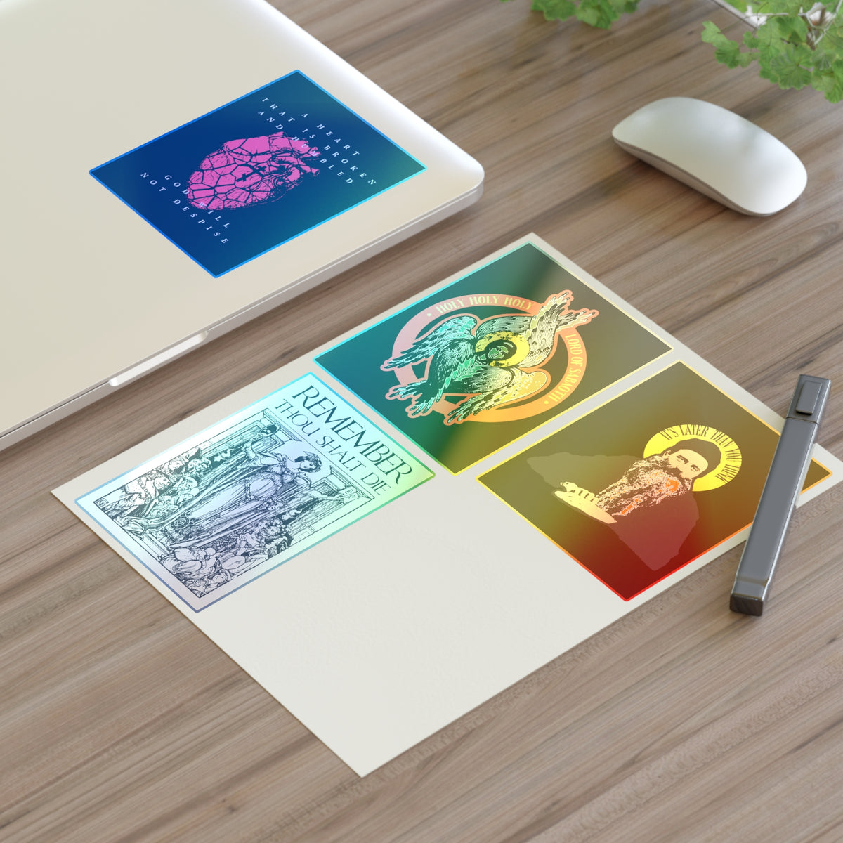 A laptop and mouse on a desk, with Bestseller Orthodox Sticker Mix No. 4 and an Orthodox Cross, plus a pen on paper.