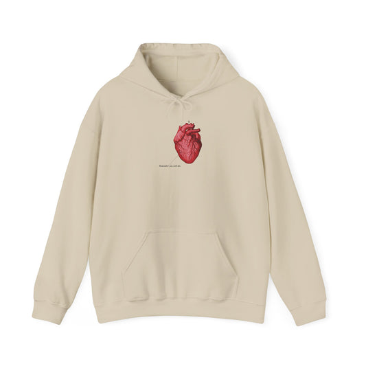 Sand-colored hoodie featuring a retro medical textbook heart graphic with an Orthodox cross and small text below on the chest, reflecting themes of memento mori and Orthodox Christian spiritual healing.