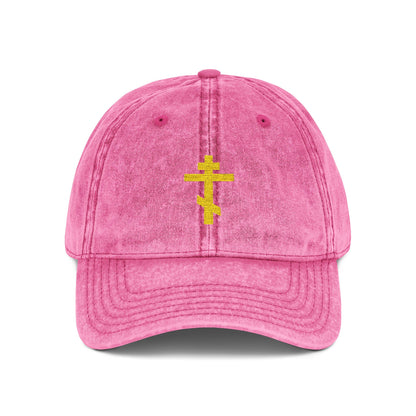 Simple yellow Orthodox TriBar Cross cap in bright pink, featuring minimalist embroidery and "Crucify My Ego to the Precious and Life Giving Cross" design; a distressed Christian statement accessory.