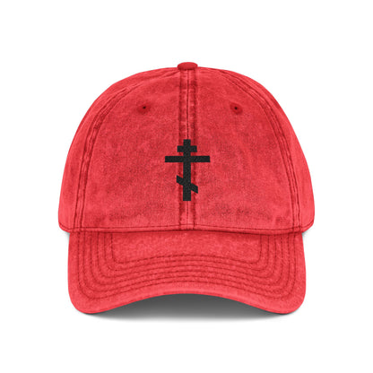 Red minimalist distressed cap, featuring a simple black Orthodox TriBar Cross embroidered on the front, inspired by "Crucify My Ego to the Precious and Life Giving Cross.