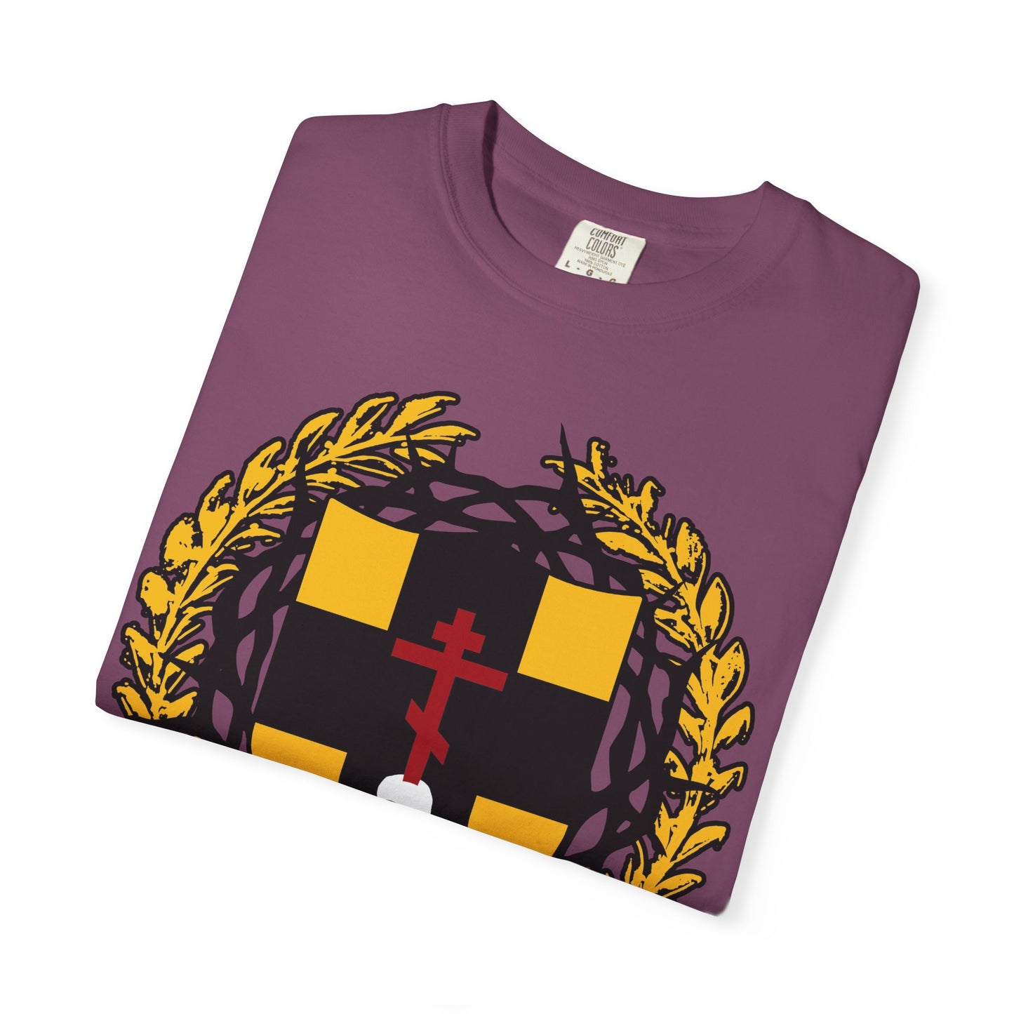 Folded purple “First-Born from the Dead (Col 1:18)” heavyweight cotton unisex t-shirt, featuring a heraldic shield with yellow squares, a red Orthodox cross stabbing a skull, and a crown of thorns—an emblem inspired by redemption through His blood and the deliverance of the firstborn in Egypt.