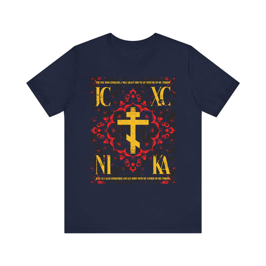 Navy IC XC NIKA Orthodox Cross t-shirt featuring a medieval floral design, gold cross, red and yellow accents, and "The One Who Conquers" from Revelation 3:21. Lightweight cotton unisex fit.