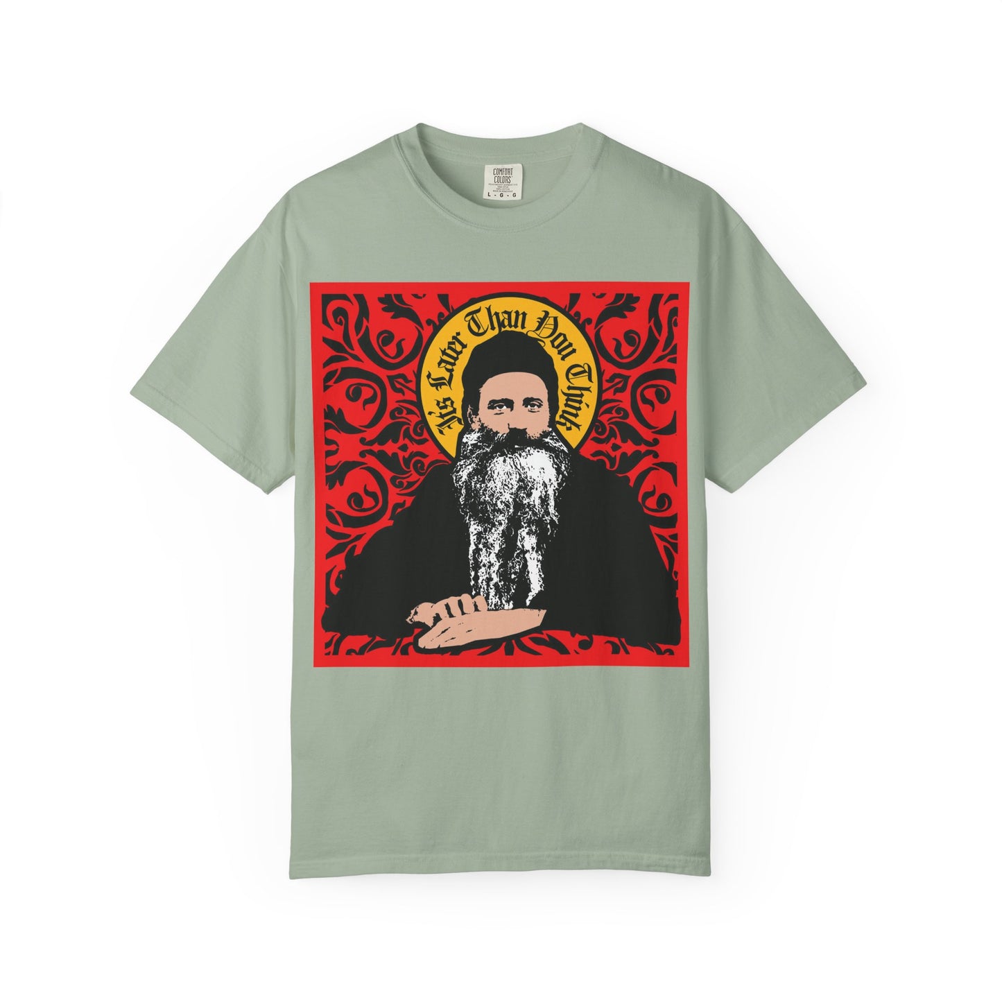 Bay-colored heavyweight cotton unisex tee featuring a Saint Seraphim Rose of Platina icono-graphic style image—a bearded man with an ornate red and yellow background—printed on the front. Product name: "It's Later Than You Think.