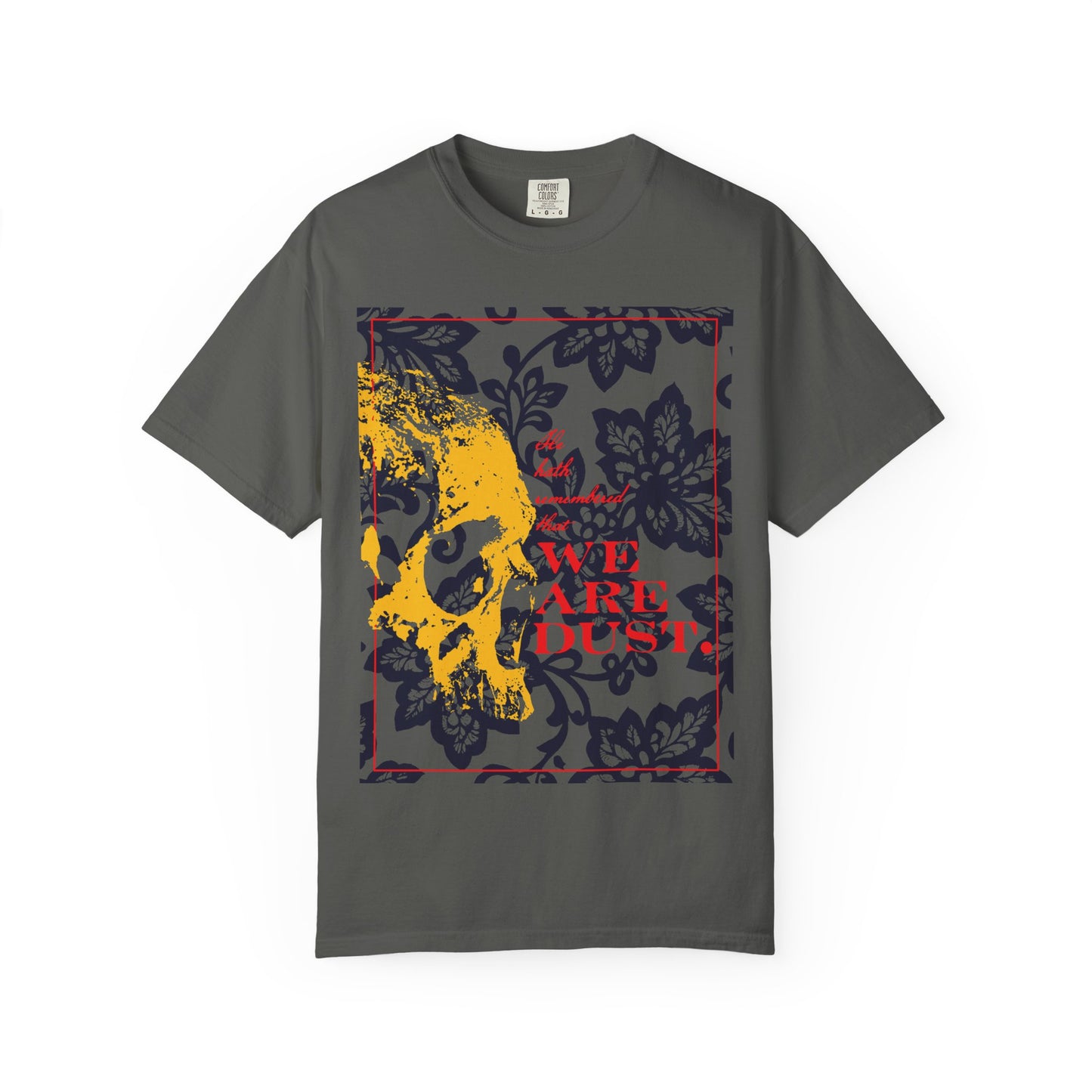 Pepper-colored heavyweight cotton unisex T-shirt featuring a yellow skull on a blue floral background with bold red "We Are Dust" text—a memento mori design inspired by Psalm 102, reminding us of our humility and the Lord’s mercy.