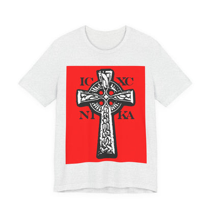 Ash T-shirt with a bold red rectangle featuring a black and white ICXC NIKA Celtic Knotwork Cross, Greek letters, and "Jesus Christ Conquers" design in traditional Orthodox Christian style.