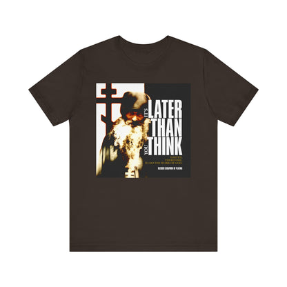 Brown T-shirt featuring an image of a bearded figure and the text: "It's Later Than You Think." The "It's Later Than You Think No. 3 Split W/ Always Remember God and Your Mind Will Become Heaven No. 1" lightweight cotton unisex tee is inspired by the way of life of Blessed Seraphim of Platina, serving as a thoughtful reminder to reflect on your time and relationship with God.