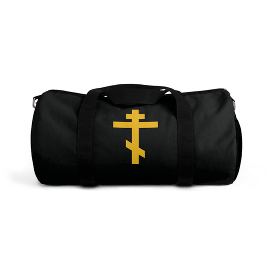 A black gym duffel bag featuring a yellow Orthodox cross, titled "Precious and Life-Giving Weapon of Unseen Warfare," ideal for Orthodox Christians.