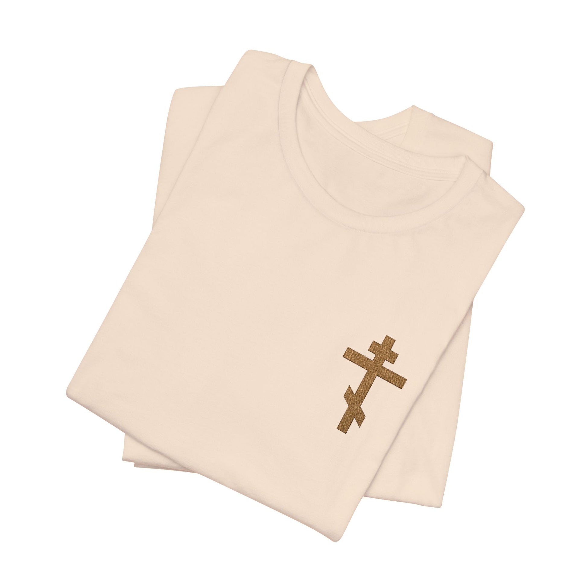 Folded white "Small Embroidered Orthodox Cross | Earthtones" unisex cotton T-shirt, featuring a brown cross and the message “May I Never Boast Except in the Cross (Gal 6:14),” displayed on a white background.