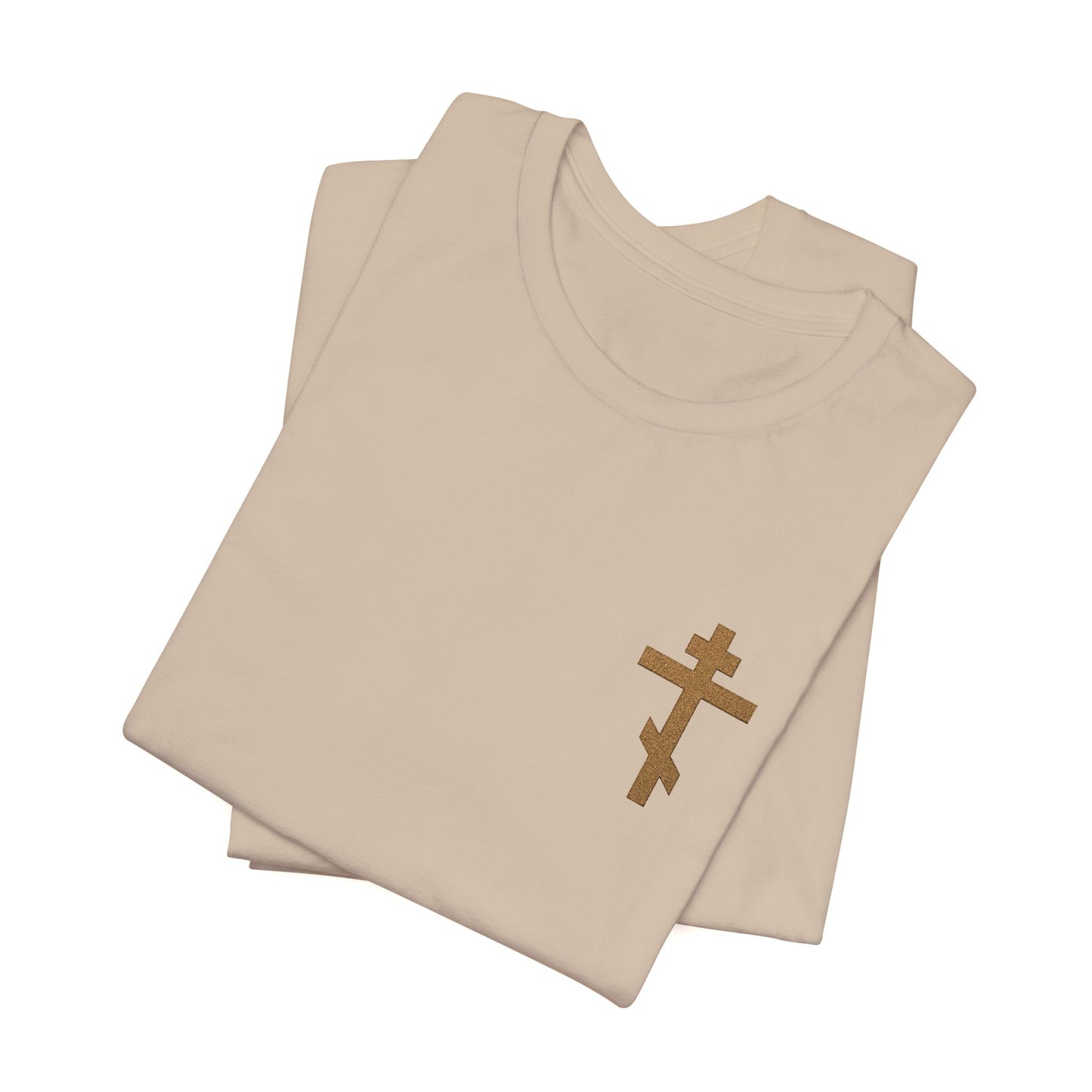 Two folded beige "Small Embroidered Orthodox Cross" earthtone t-shirts, featuring a subtle brown cross on the front left, inspired by Galatians 6:14: “May I Never Boast Except in the Cross.” Christian cotton unisex design.