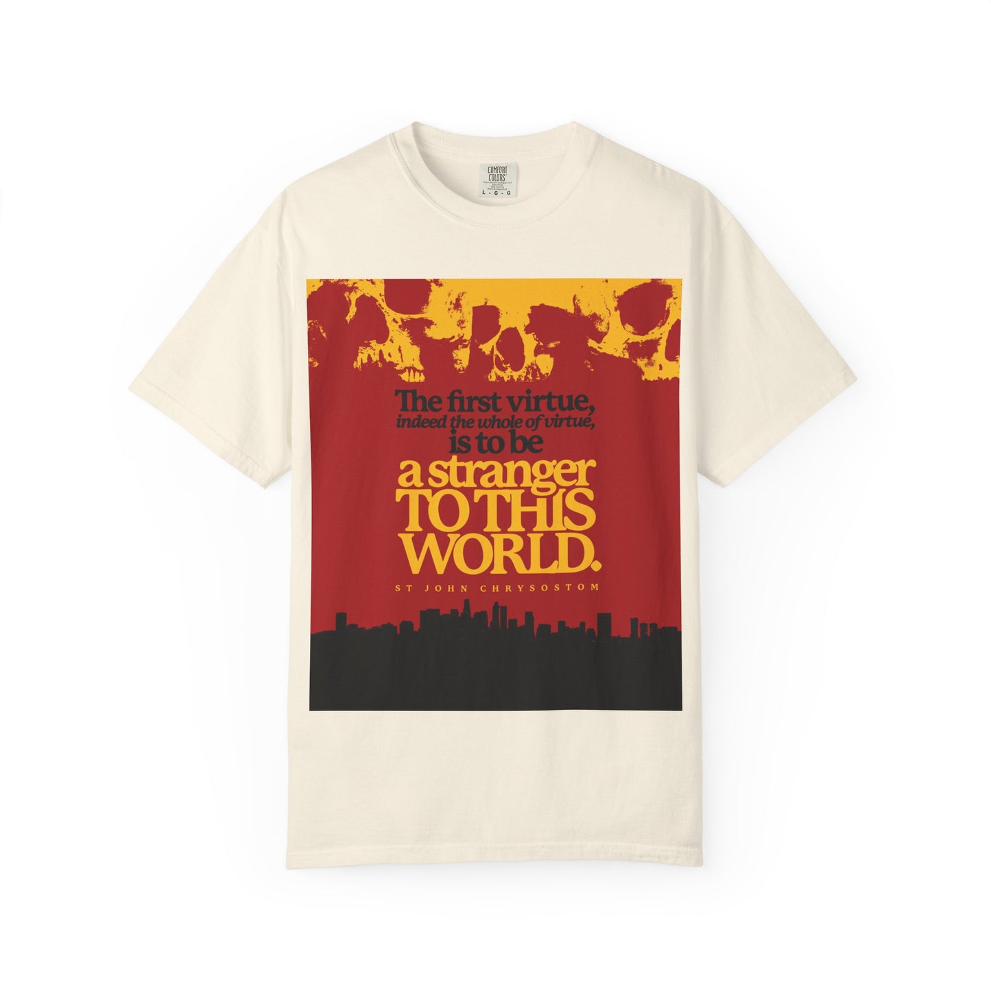 Ivory heavyweight cotton unisex T-shirt featuring St John Chrysostom's quote, "Be a Stranger To this World," with skulls and a cityscape graphic—Orthodox Christian design inspired by spiritual pilgrimage.