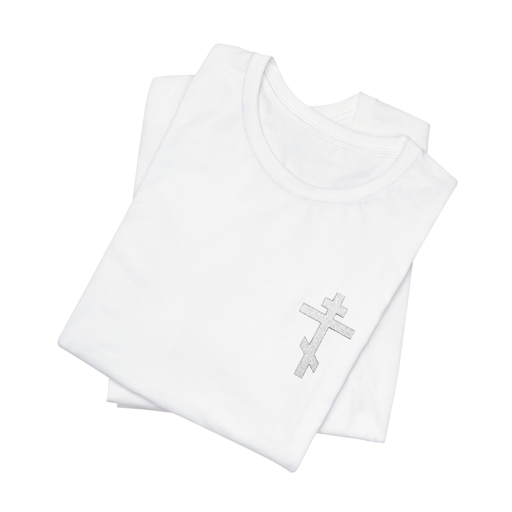 Two folded white cotton T-shirts, one featuring the "White on Light Small Embroidered Orthodox Cross" with "May I Never Boast Except in the Cross (Gal 6:14)"—a soft Airlume unisex tee.