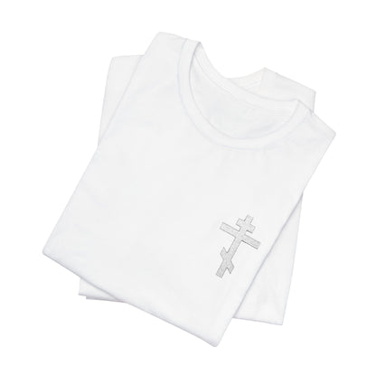 Two folded white cotton T-shirts, one featuring the "White on Light Small Embroidered Orthodox Cross" with "May I Never Boast Except in the Cross (Gal 6:14)"—a soft Airlume unisex tee.