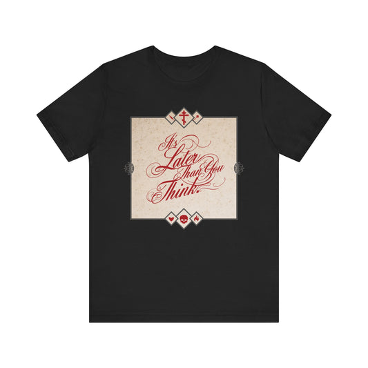 Black "It's Later Than You Think" tee with cursive red script on a beige square. Inspired by Seraphim Rose, this Orthodox unisex cotton shirt is a memento mori reminder to repent while you can and reflect on life and faith.