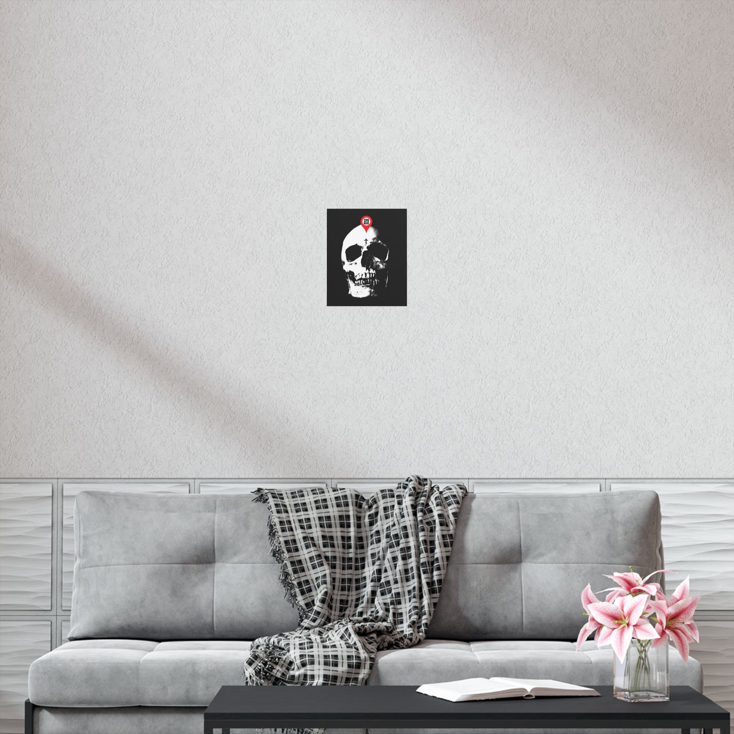 A gray sofa with a plaid blanket, a coffee table with flowers and a book, and the "You Will Be Here Maps Marker on Skull Design" Orthodox Christian art poster evoke the memento mori theme, recalling St Ignatius Brianchaninov’s reflections on spiritual death.