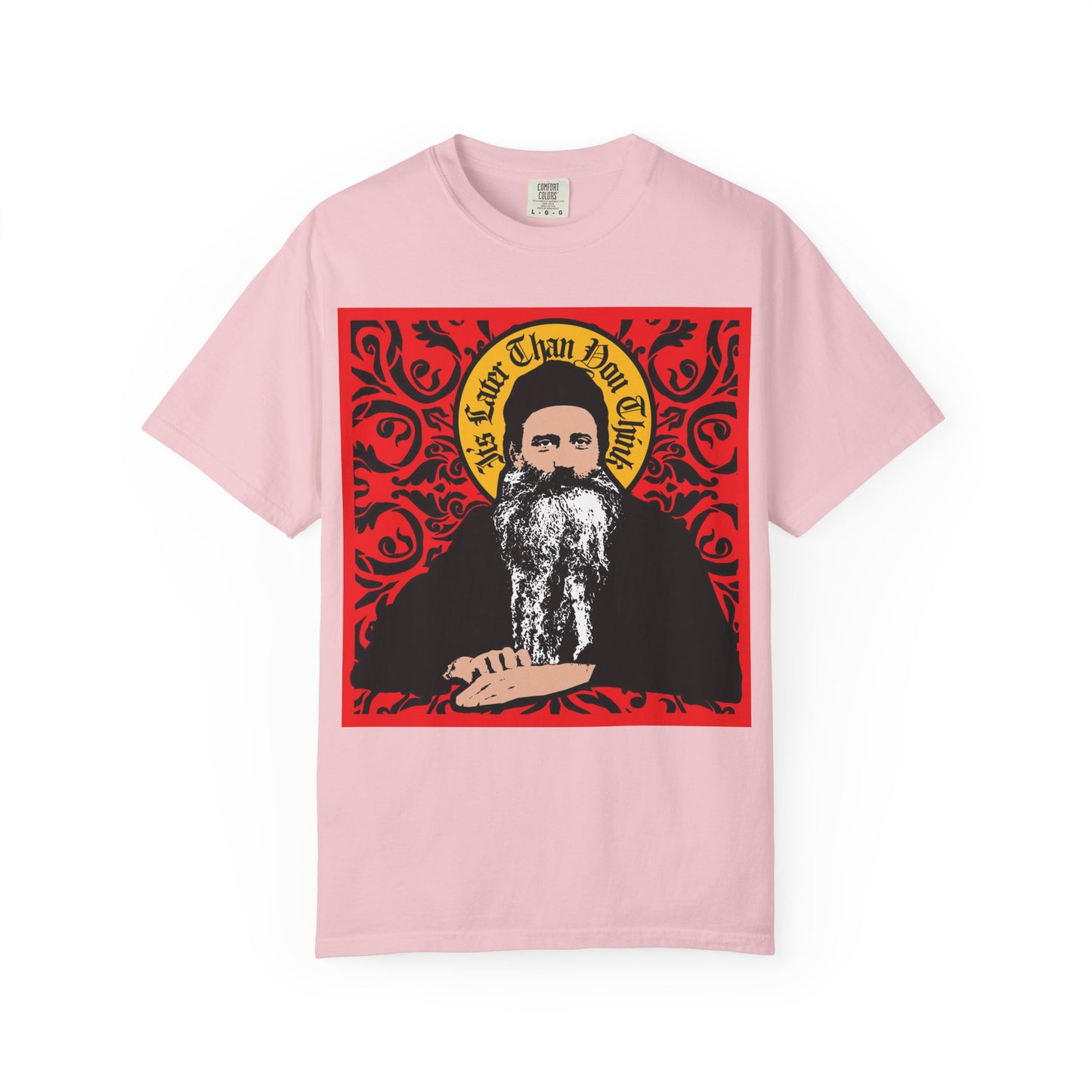 Blossom-colored "It's Later Than You Think" heavyweight cotton unisex tee featuring a stylized iconographic design of Saint Seraphim Rose of Platina, with an ornate red and black background inspired by Orthodox Christian themes.