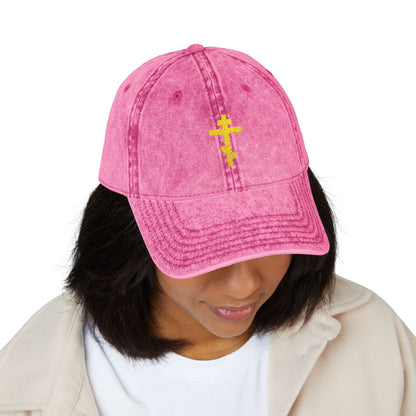 Woman wears the Simple Yellow Orthodox TriBar Cross Cap—embroidered with a minimalist cross and “Crucify My Ego to the Precious and Life Giving Cross”—a subtle expression of faith in a distressed, pink Christian baseball cap.