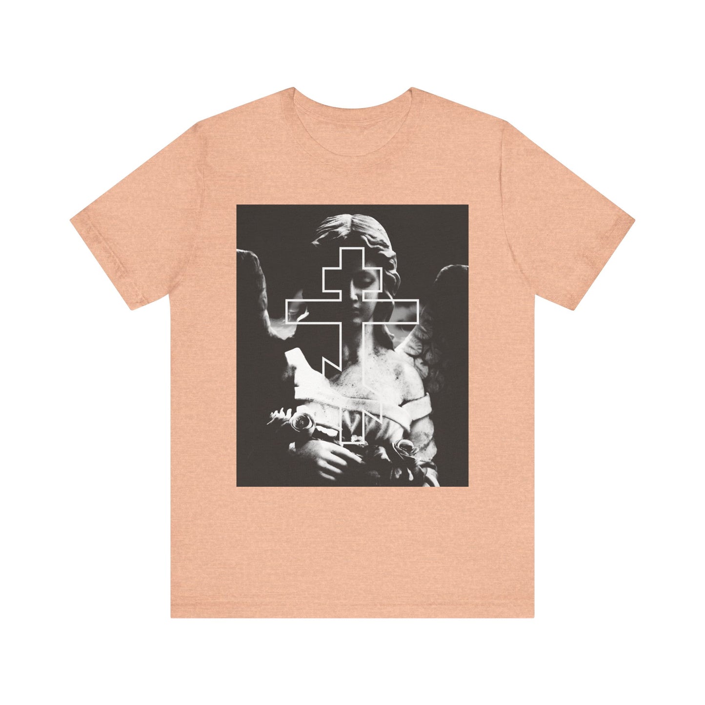 The Cemetery Angel Orthodox Cross tee in heather peach features a grayscale angel with an outlined cross, merging goth aesthetic and memento mori symbolism on lightweight cotton.