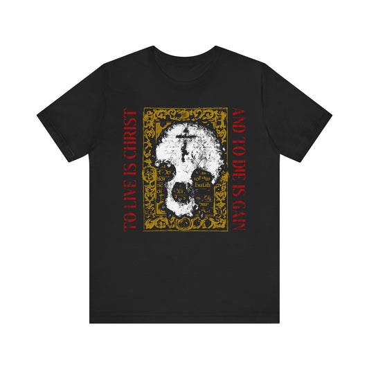 Black unisex tee featuring a white skull with cross on gold manuscript texture and red Philippians 1:21 text—"To Live is Christ, To Die is Gain"—a bold reminder of Christian faith.