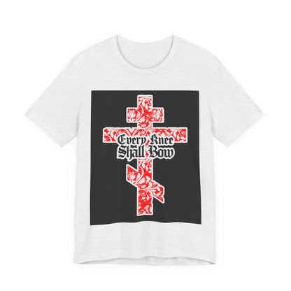 White unisex tee featuring a gold and red floral Orthodox cross with gothic “Every Knee Shall Bow” text, inspired by Isaiah 45:22-24 & Phil 2:7-11, proclaiming Jesus Christ’s majesty.