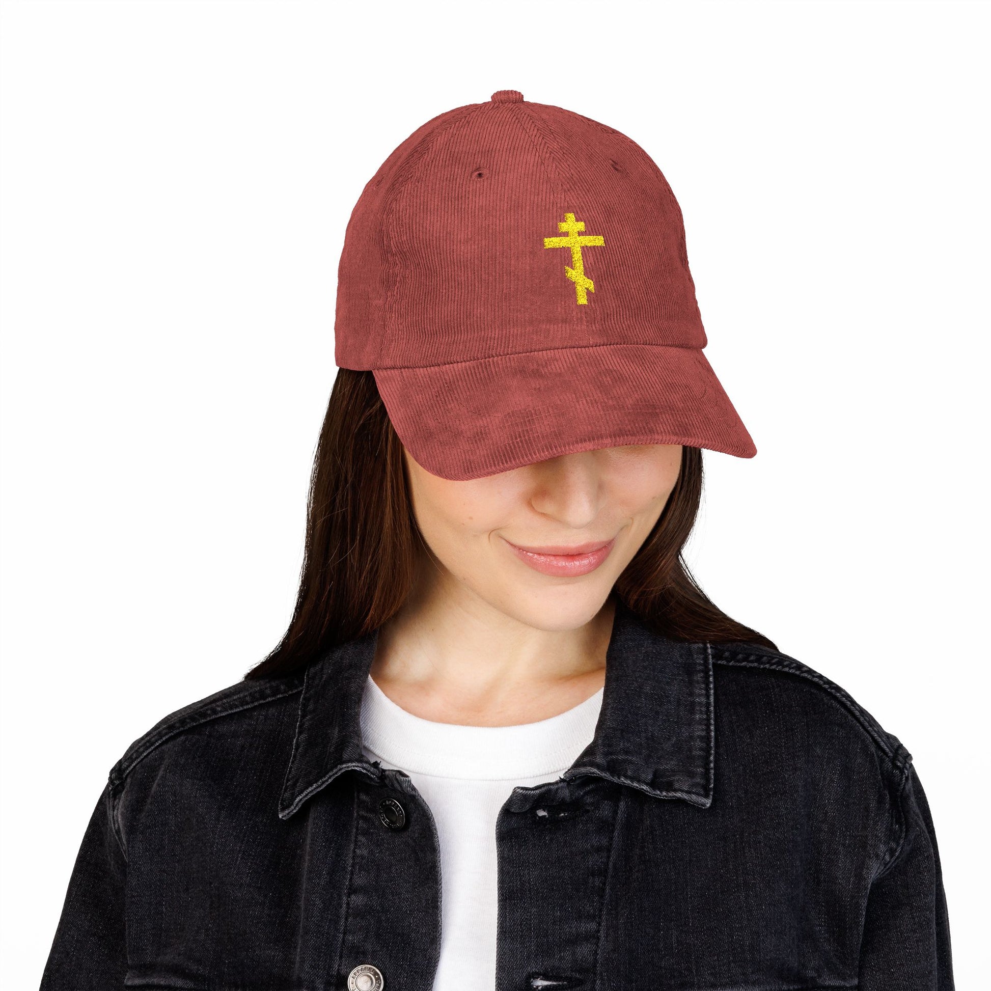 Woman wears a Simple Yellow Orthodox TriBar Cross Cap—an embroidered cotton corduroy hat symbolizing salvation and spiritual warfare—paired with a black denim jacket and white shirt.