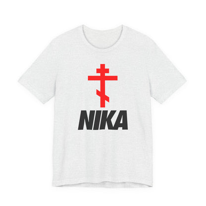 An ash T-shirt features a red Orthodox cross above bold black NIKA text, blending classic iconography with minimalist design in this athletic Christian tee inspired by the iconic NIKE logo.