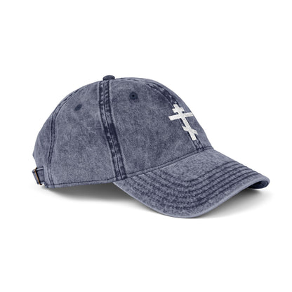 Minimalist blue denim cap with a white Orthodox TriBar Cross, symbolizing Christ’s crucifixion. Features "Crucify My Ego to the Precious and Life-Giving Cross" embroidered design. Distressed, simple Christian style.