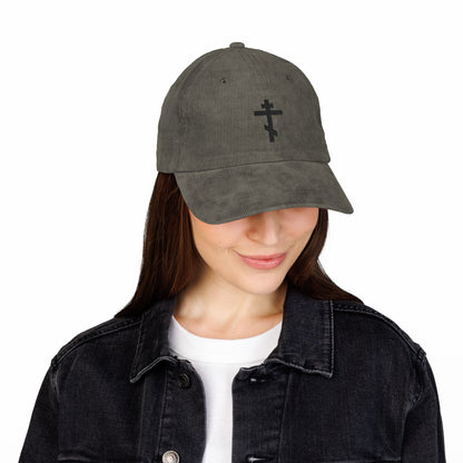Woman smiling and looking down, wearing a black denim jacket and the Simple Black Orthodox TriBar Cross—an Orthodox Christian Embroidered Cotton Corduroy Cap, Weapon of Unseen Warfare Which Makes Demons Tremble.