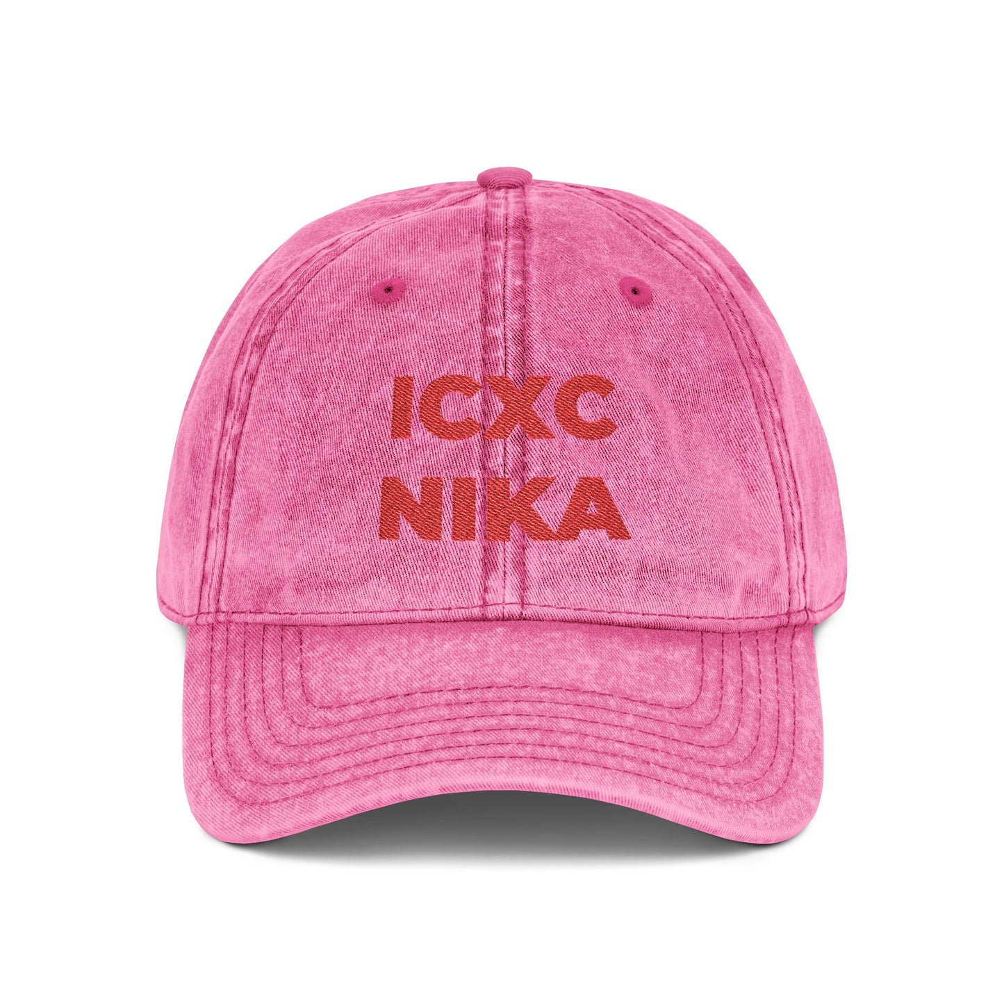 Pink distressed denim cap featuring red embroidered "ICXC NIKA" Christogram, meaning "Jesus Christ Conquers." Orthodox Christian symbol; Christ is King.