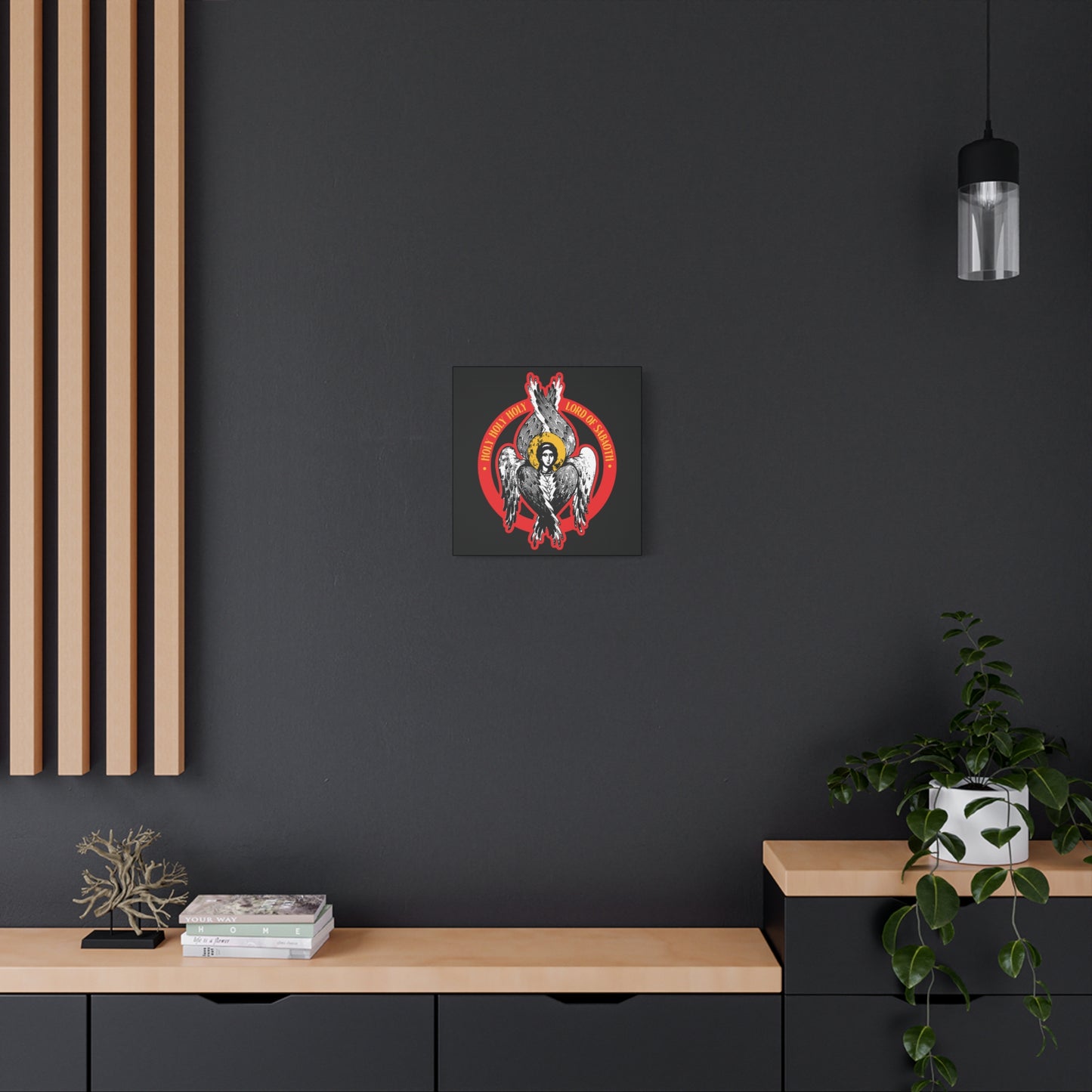 A dark modern wall with the "Holy Holy Holy, Lord of Sabaoth | Isaiah 6 | Orthodox Seraphim Angel IconoGraphic" Christian Wall Art, books, a metal tree sculpture, and a potted plant creates a reverent atmosphere inspired by Isaiah 6.